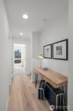 Photos of model home 9213 with similar finishes & floor plan. A hallway with purpose! Perfect spot for a gallery wall or a stylish desk setup like this one.