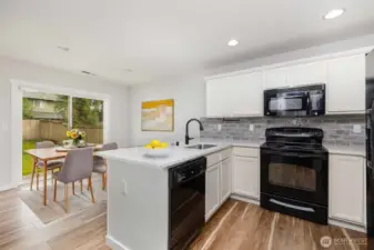 The kitchen and dining area are subtly separated, providing a perfect balance of openness and defined space for both cooking and dining. - Virtually Staged