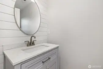 Bright and crisp main floor half bath, conveniently located off the living room for easy access and guest convenience.