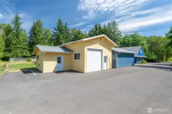 Garage with loft area and room with washer and dryer and bathrooom and dog grooming/bathing sink. Currently set up as a shop space and dog grooming room.
