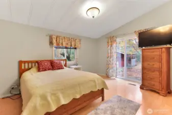 Primary bedroom has an attached bath, custom closet and slider access to front/side yard.