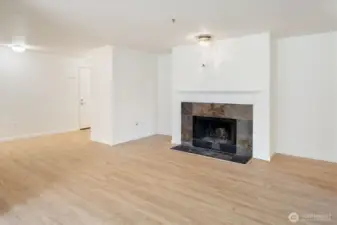 The living room is bright, warm, and welcoming: natural light and a wood burning fireplace ensure seasonless comfort.