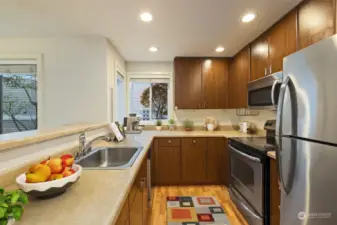 Virtually staged. Convenient bar top plus plenty of storage. Stainless steel fridge, stove, micro, and dishwasher stay!