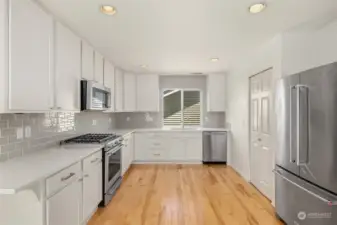 Stunning kitchen with an abundance of white cabinetry and a pantry for extra storage.