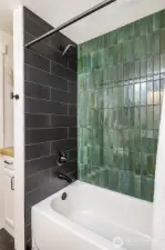 A full bath with a tub is ideally situated off the living room and kitchen, offering easy access for guests and family alike