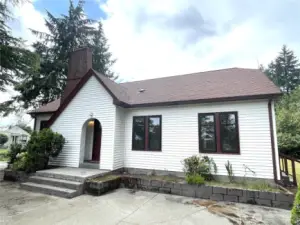 A graceful sloping gabled room leads to an inviting arched entry to the vestibule. Vinyl siding makes for low maintenance.
