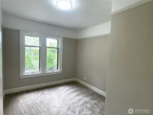 The primary bedroom features two windows looking towards Mt. Rainier and the Cascades. New carpet, trim and lighting with fresh paint throughout.