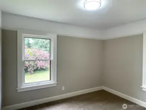 Bedroom number three has two expansive windows that look out to the beautiful flowering mature plantings.