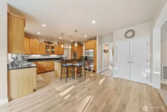 Kitchen features eating bar, stainless steel appliances, beautiful hardwood floors, and large pantry.