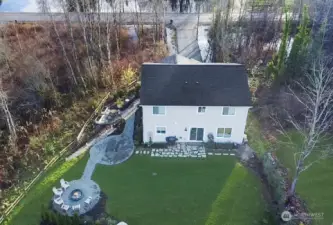 Side yard features gardening area, outdoor dining, and firepit