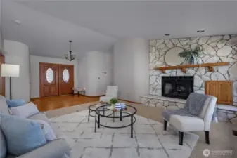 Stone fireplace anchors this spacious living room filled with natural light.