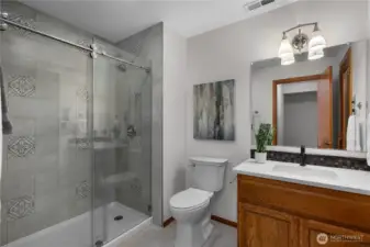 Updated lower-level bath with stylish tile shower and modern finishes.