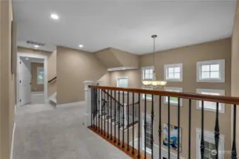 Experience the grandeur of the home's design as you walk through the upstairs hallway, with its elegant railings that allow you to look down into the main level, creating a sense of openness and connection throughout the house.