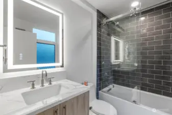 Main floor fully tiled bath, all bathrooms have heated floors and lighted mirrors