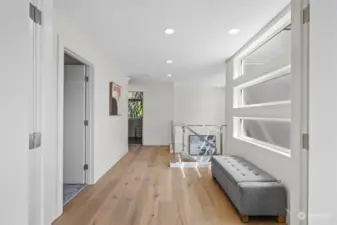 Upstairs light filled hallway to walk in laundry room and 3 bedrooms