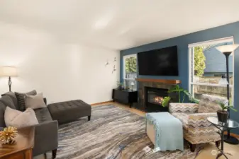 Light and Bright Living Room With Wood Burning Fireplace and Large Windows Overlooking the Fenced Yard