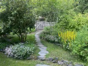 An entry path meanders through the gate that keeps the garden safe from deer.