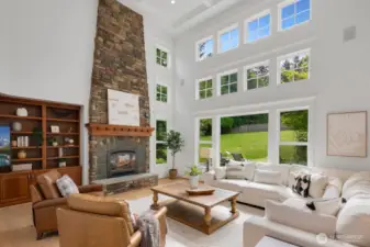Wow family room with vaulted boxed ceilings, floor to ceiling stone fireplace and windows that keep it bright and cheery all year round.
