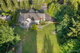 Expansive view of back of home and backyard. Don't miss the garden space with raised beds and fruit trees. 19 zone sprinkler system.