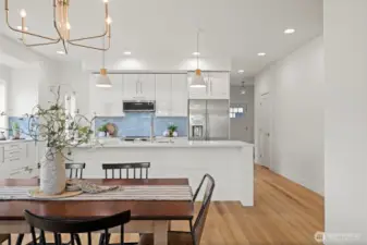 Looking toward the front entry with the powder room on the right beyond the kitchen.