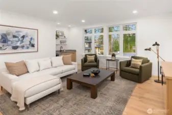 Second floor rec room features wide plank hardwood flooring (also included in entire lower level, stairs, upper hallway, and primary bedroom) Built in rift oak cabinets with prep sink and under counter beverage center, and floating rift oak component cabinet
