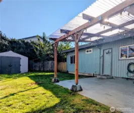 View to storage shed, fenced side yard area, and covered patio