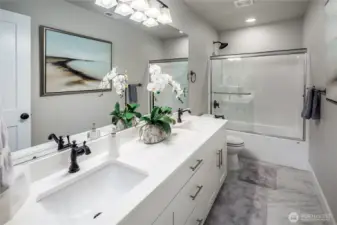 Hall bathroom has quartz counter tops with double undermount sinks and a full tub/shower combo.