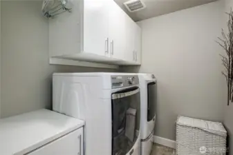 Upstairs laundry room with folding counter and cabinets. Upscale washer & dryer stay with the home.