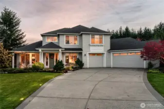 Front exterior at dusk. Showcasing long driveway and driveway lights.