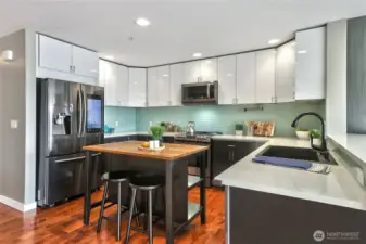 The kitchen boasts induction range, high-end appliances, quartz counters, glass tile backsplash and convenient island.
