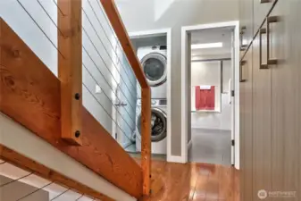 View to the laundry center and full bath. A guest bedroom is at the end of the hall to the right.