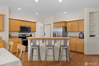 Casual bar seating invites morning pancakes, after-school homework, and late-night chats over a glass of wine.