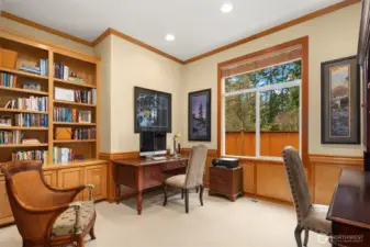 The large main level den/office allows the space for two desk areas, with built-in cabinets, shelving, and shows the signature trim details including chair rail and crown molding.