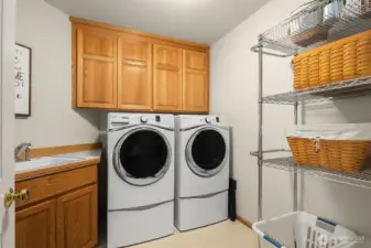 The large laundry room features a utility sink and storage cabinets.