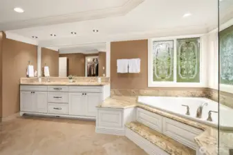 Spacious primary suite ~ serene views of the greenbelt. Large, lavish, spa-inspired en-suite bath with frame-less glass door dual head shower, heated Travertine tile floors, soaking tub, and large walk-in closet.