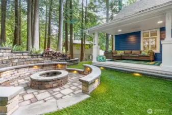 Professionally designed and installed backyard hardscape with a circular fireplace.