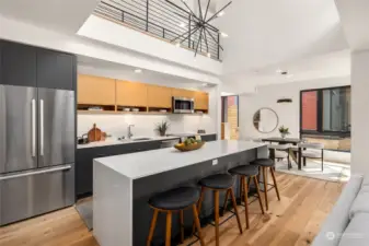 The large island featuring a stunning quartz waterfall counter not only offers ample storage but also serves as a central hub for dining and entertaining, making it a beautiful, versatile and functional feature of the kitchen.