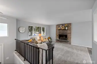 The welcoming living room features a modern & harmonious palette complete with a cozy wood burning fireplace.