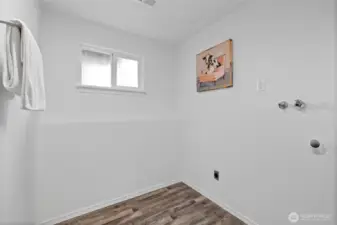 Utility room shared space with 3/4 bathroom located on the lower level.