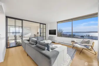 Custom steel and glass partition adds an artful design to the sprawling living area and provides a beautiful separation of space.