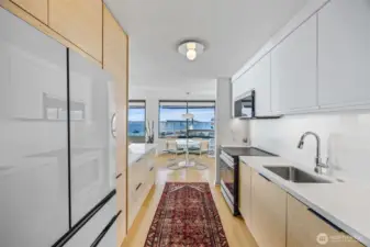 Luxurious renovated kitchen with pure white quartz counters and custom twig maple lower cabinet fronts.