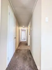 Hallway leading to the utility room, main bath & bedrooms.