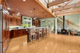 Vaulted ceilings and exposed beams elevate the main living space, giving it a lodge-like presence. Sunlight pours in through oversized windows, highlighting the craftsmanship throughout. It’s a room designed for gathering and relaxing.