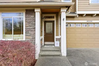 Covered front entry with stone accents and two-car garage