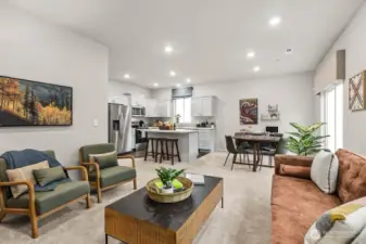 Another photo of the great room with the dining area and kitchen in the background. Photos are representative only and may display different color package and/or upgrades.