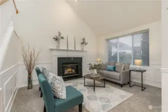 Elegant wainscoting, gas fireplace & cathedral ceiling in the formal living room