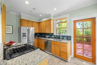 Stainless appliances, & gas range with tiled floor is sunny and bright