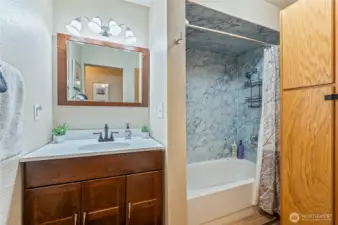 Main floor bathroom featuring a tub/shower combo for family and guests.