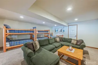 Spacious recreation room with two bunk beds and a queen bed—ideal for family and guests.