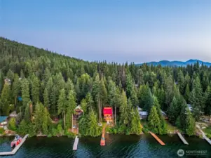 Aerial view showcasing private dock, 0.40-acre lot, surrounding forest, and the Cascade Mountains in beautiful Leavenworth, WA.